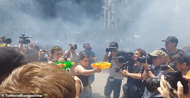 Protestors seen firing water pistols at shop windows, setting off coloured smoke and clashing with police in Barcelona on Sunday