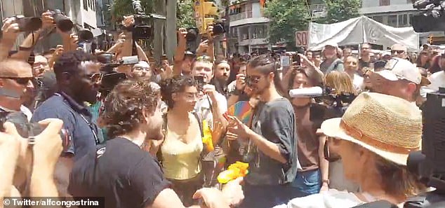 The employee is seen firing a water gun at protesters