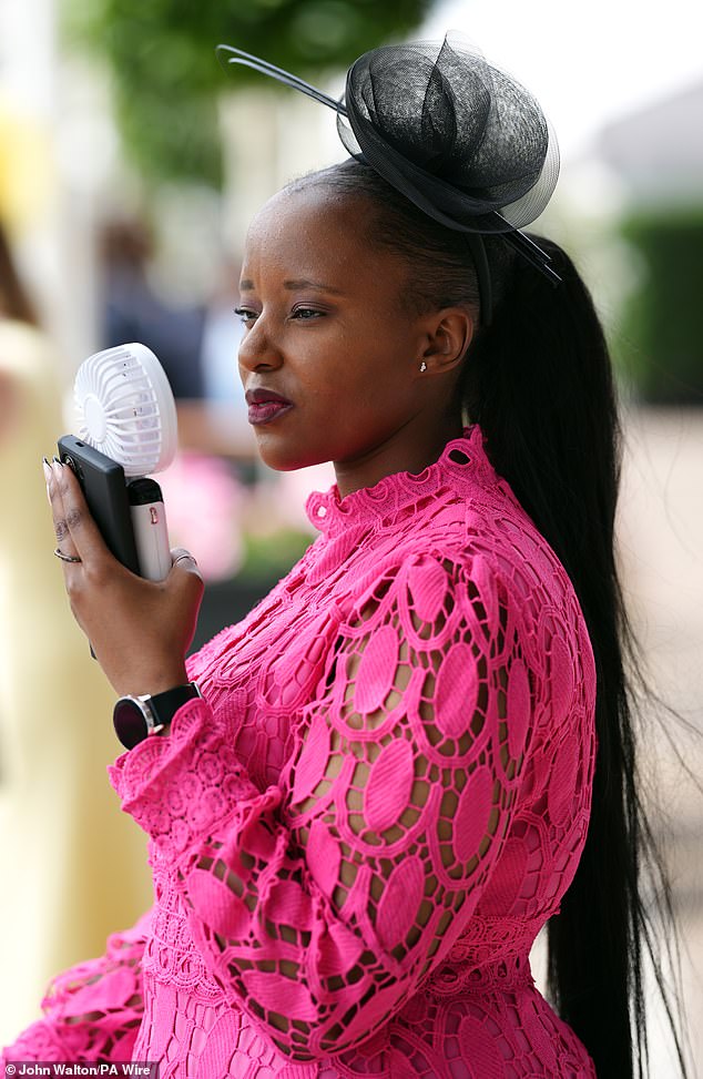 One racegoer appeared to be struggling with the heat already as she put a portable electronic fan in front of her face