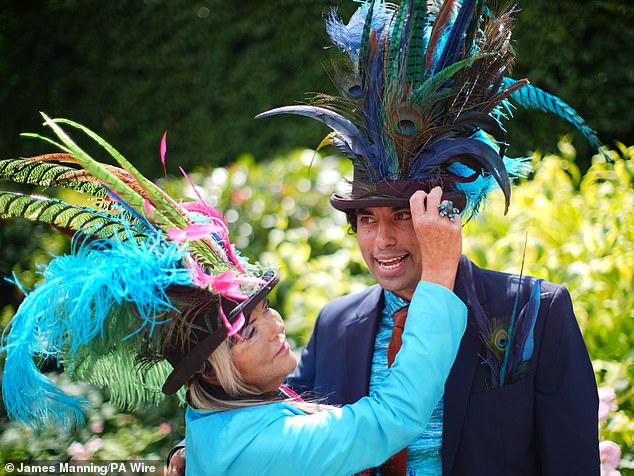 Flamboyant fascinators stole the show at Royal Ascot on Friday as two racegoers sport headpieces adorned with peacock feathers