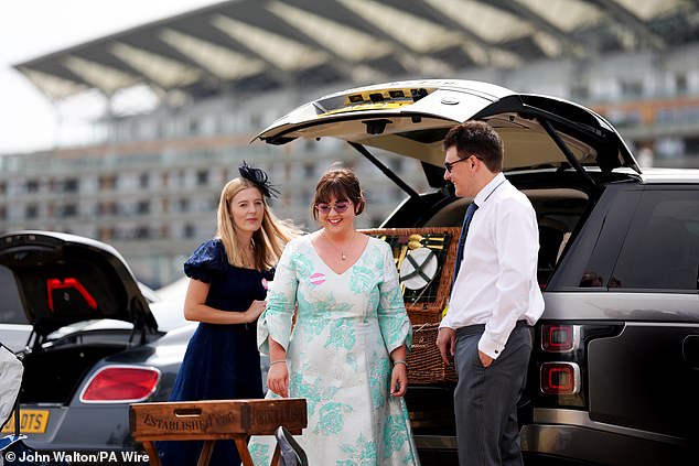 Well-dressed revellers were snapped setting up their picnic baskets ahead of the long day
