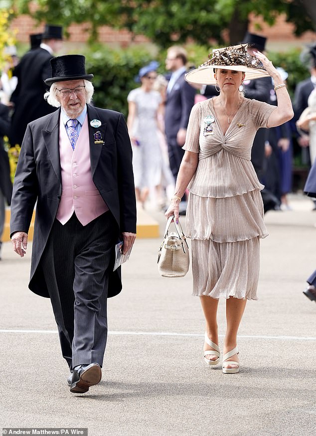 Racegoers were dressed to the nines in elegant attire consisting of large hats and three-piece suits complete with top hats