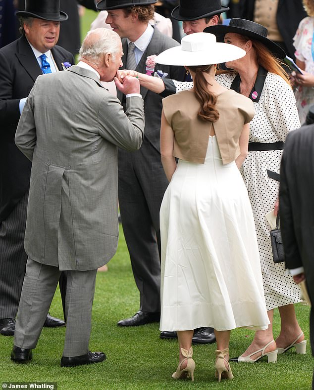 A kiss for Fergie! The King pecks the hand of Sarah Ferguson at the Berkshire racecourse