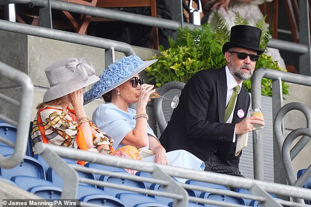 The couple sipped on flutes on bubbly as they chatted and laughed with friends sat around them