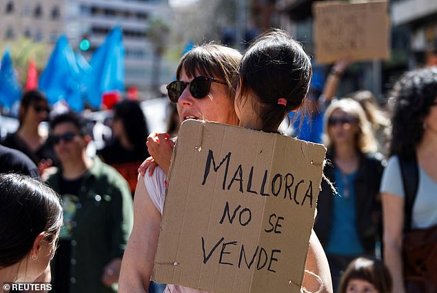 Mallorca is not for sale' reads a protest banner held by a girl in a march against housing prices and the impact of tourism on the residents of the Balearic Islands, in Palma, Mallorca, Spain