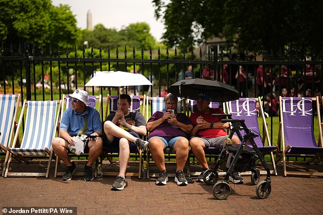 Forecasters predict highs of 34C (93F) in parts of eastern England such as Cambridgeshire, and 30C in the North East. Pictured: People shield from the sun under umbrellas in Victoria Embankment Gardens, London, on June 20