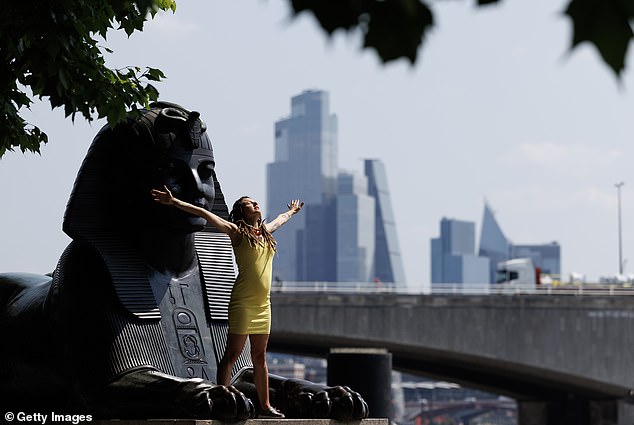 The hot weather is poised to linger in the South and East through the weekend. An amber heat health alert ¿ to warn healthcare providers ¿ lasts until Monday.Pictured: A woman dances on a statue of a Sphinx next to the River Thames in London