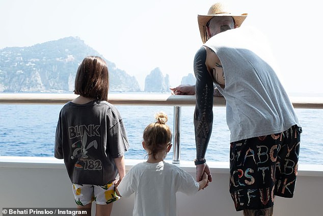 One sweet shot shows the Sugar singer and one of his daughters and perhaps his son, holding hands as they looked over the rail of the yacht and into the horizon