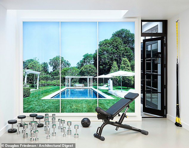 A cleverly positioned lightbox in the sprawling basement gym features a photograph of the rear garden and pool of the couple’s East Hampton home – a soothing backdrop to a morning workout routine.