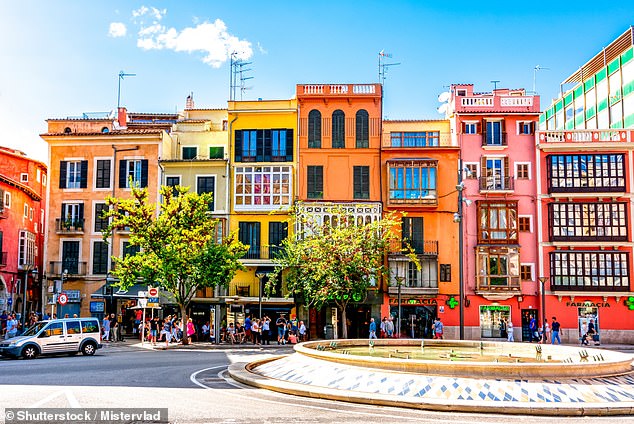 Palma can be explored on foot or by bike. Above, colourful houses line the city streets