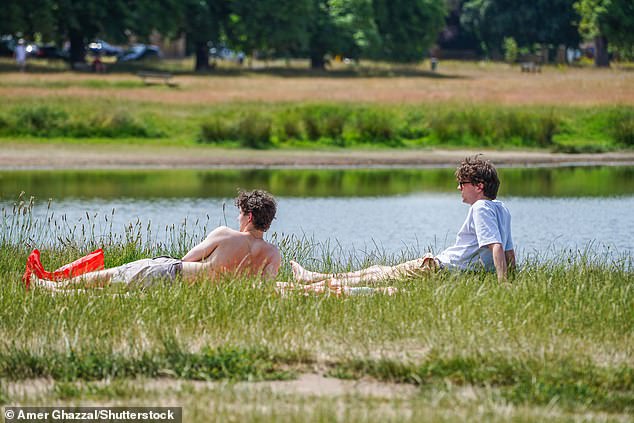London: Two men enjoying the soaring temperatures on Wimbledon Common as the heat gears up to 34C