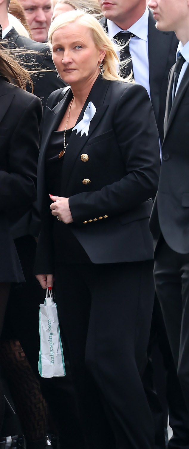 Gangster's moll Joanne Byrne follows the coffin of her father James 'Jaws' Byrne on September 13, 2024, while holding a bag from a vape store