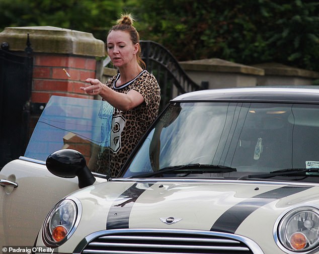 Kelly Quinn flicked the cigarette to the ground before getting inside the Mini Cooper