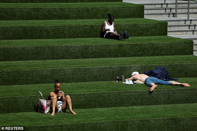 This week has already seen thermometers surpass 30C across much of the UK, with Scotland, Wales and Northern Ireland all recording their warmest days of the year on Friday (Pictured: Sunbathers in Canary Square, London, June 21, 2025)