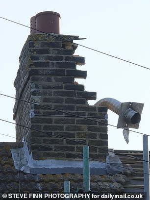A dilapidated chimney is pictured