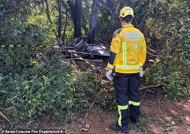 This photo released by the Santa Catarina Fire Department shows a rescue team member at the crash site after a hot air balloon carrying 21 people caught fire and plunged, in Praia Grande