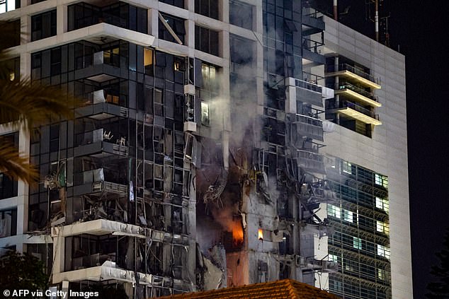 Footage from a local TV channel has shown a huge hole blasted into a building in Tel Aviv with fires raging inside
