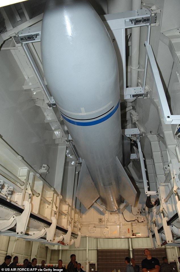 This US Air Force handout photo shows weapon specialists looking on as a mock up of the Massive Ordnance Penetrator sits in a bomb bay of the B-2 weapons load trainer