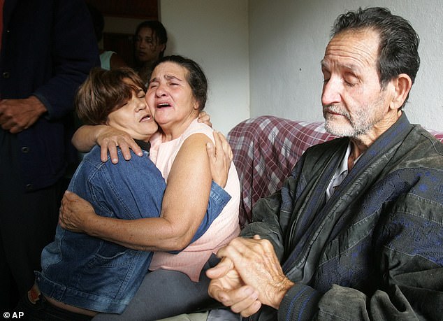 Pictured: Aparecida Menezes, left, comforts her sister Maria Otone de Menezes, center, mother and father of Jean Charles de Menezes at their home near Gonzaga, Brazil, in the aftermath of Mr Menezes' death in 2005