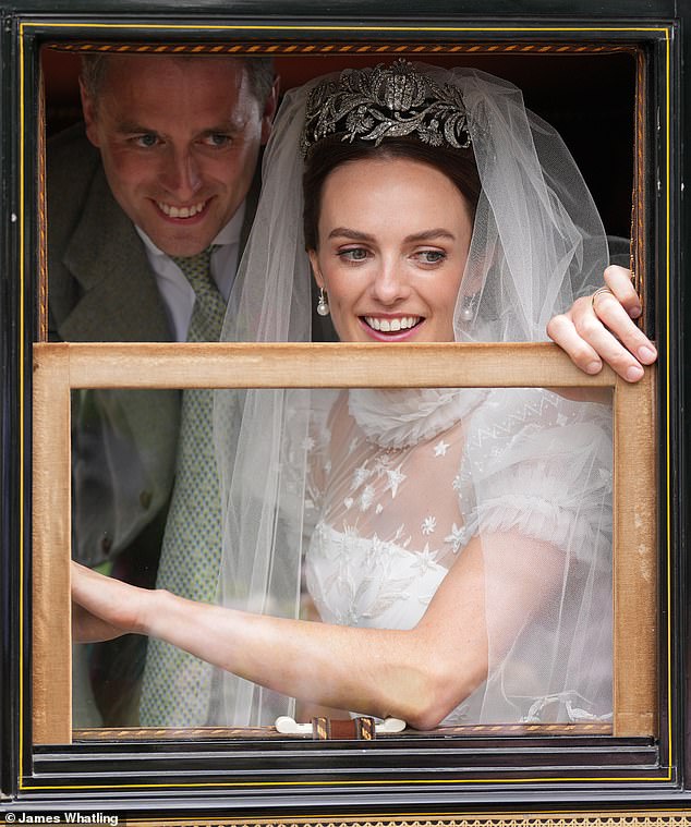 The happy couple, who announced their engagement last summer, wave at guests and well-wishers after being named man and wife