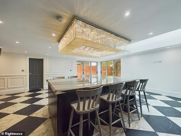 The dining area has a massive glass chandelier that hands off the ceiling ominously over a table
