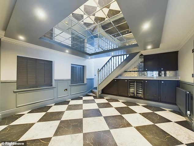 Close by, there is another strange aspect to grace the ground floor ceiling - in the form of a massive mirror that reflects the black and white chequered kitchen floor