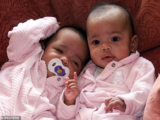 Two six month old twin girls, Kimberley (right) and Belinda (left) sit on a sofa in Chester in Jan 2001