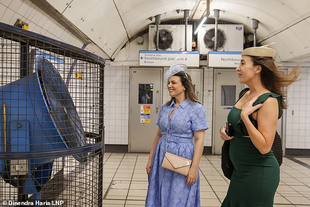 According to Network Rail, Britain's railways are more likely to buckle during a heatwave given the tracks are made from steel. Pictured: women travelling to Royal Ascot cool off in front of a large fan on the London Underground on June 19