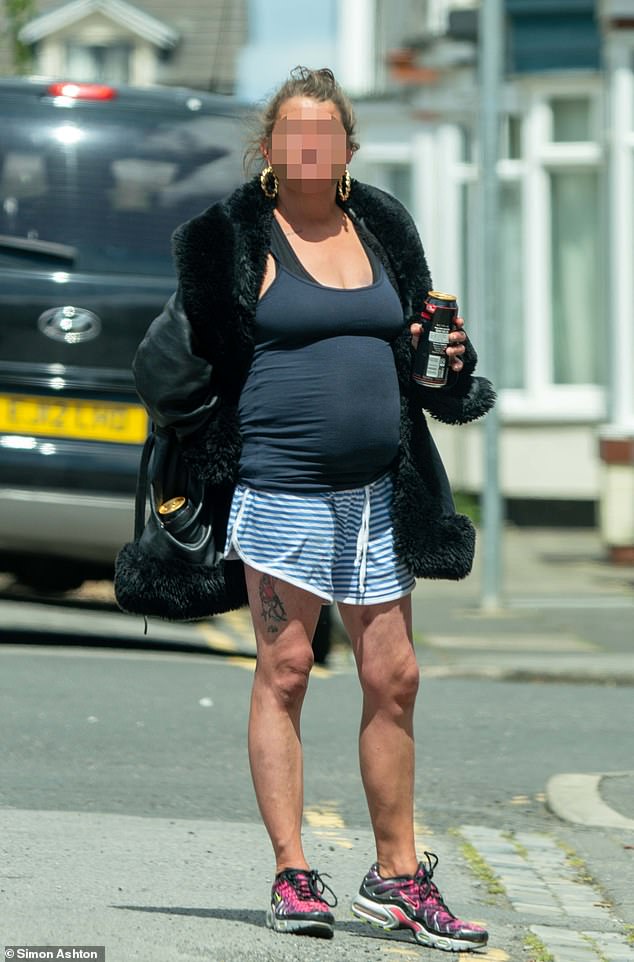 A local woman stands on Hartington Road holding a can of alchohol, with another can in her handbag