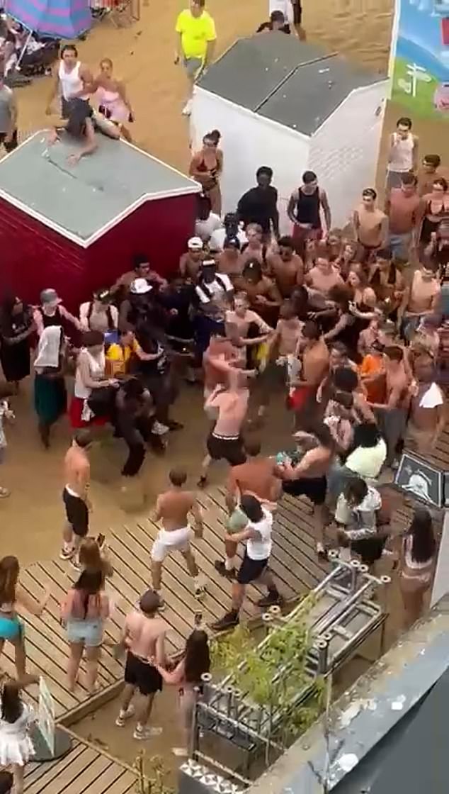 Astonishing footage of the fight shows hundreds of youths surrounding two males who are throwing punches and slaps at each other on the walkway behind a row of beach huts on the Kent seafront