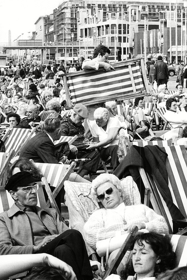 Holidaymakers sit in deck chairs at the seafront in Blackpool, 1979