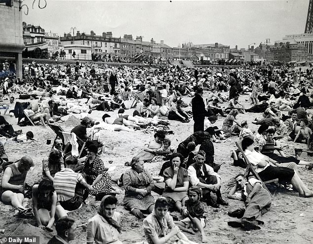 Holidaymakers are pictured relaxing on Blackpool Beach during a war-time August Bank Holiday in 1943