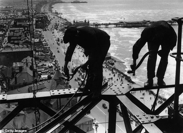 Balancing on girders high above the promenade, workmen repair Blackpool Tower, August 15, 1934