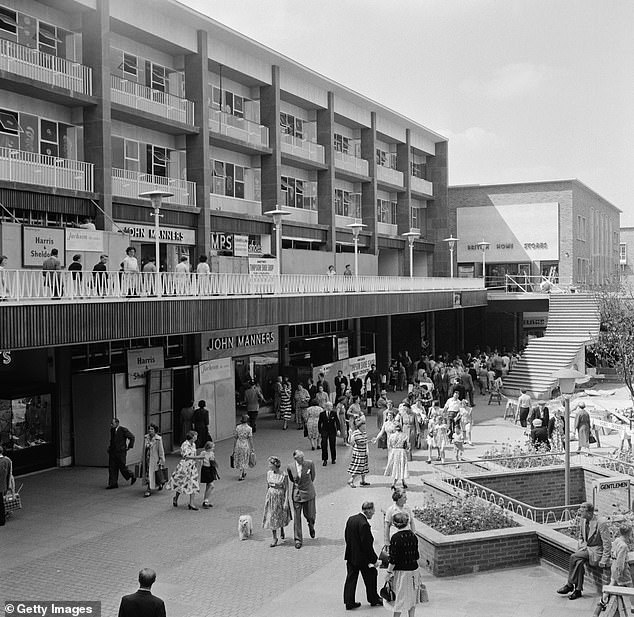 Australian-born British actress and singer Cicely Courtneidge and her husband, British actor and director Jack Hulbert walking their poodle among pedestrians in the rebuilt shopping precinct in Coventry, Warwickshire