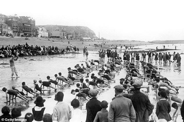 Above, a drill instructor is photographed leading children in a workout on Hastings beach in the late 1920s