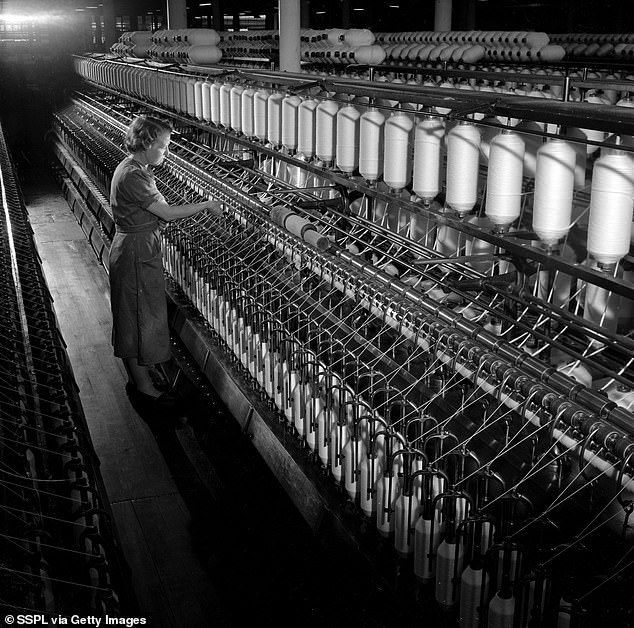 A worker adjusts machinery at Knowles Carpet Mill in Bolton, 1957