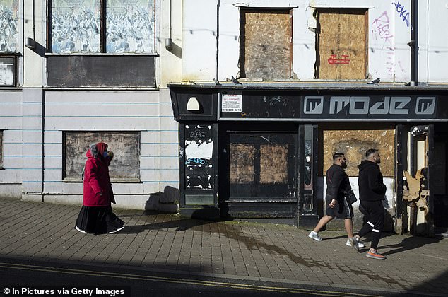 Residents walk past an abandoned nightclub in Bradford, March 2022