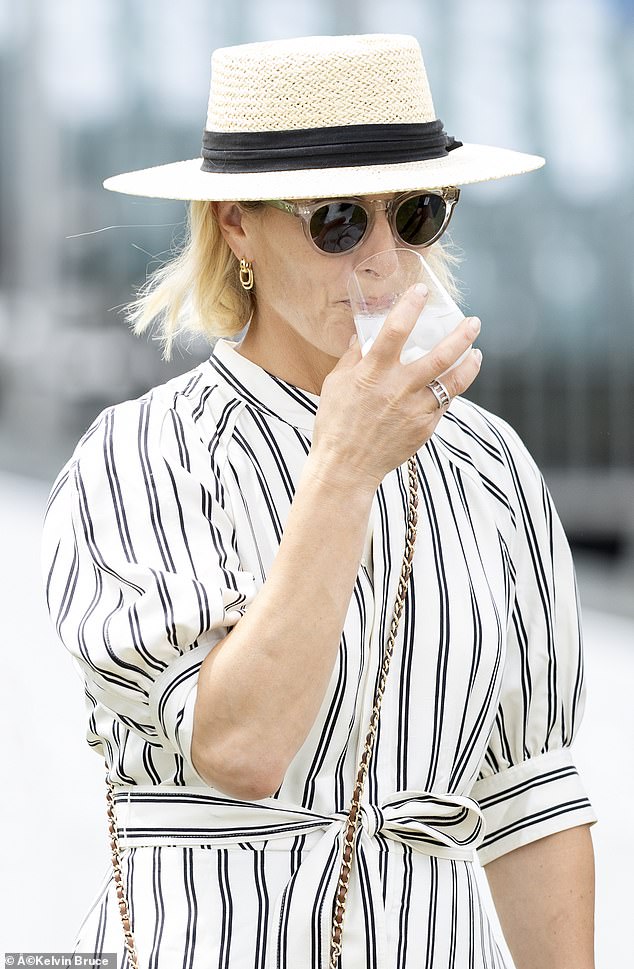 Keeping cool: Zara enjoys an iced tipple as she tours the Guards Polo Club in Windsor