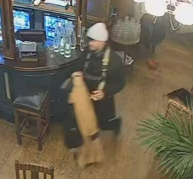 He then removes his jacket to reveal black clothing underneath, and can be seen carrying a violin-sized black case