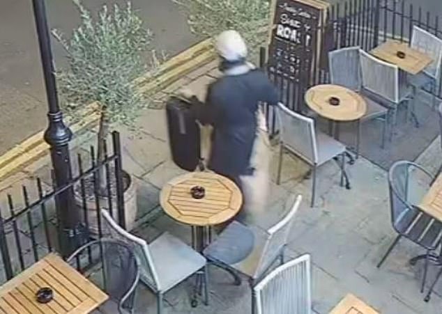 He then exits the pub and walks out onto the street with the case and coat in his hands