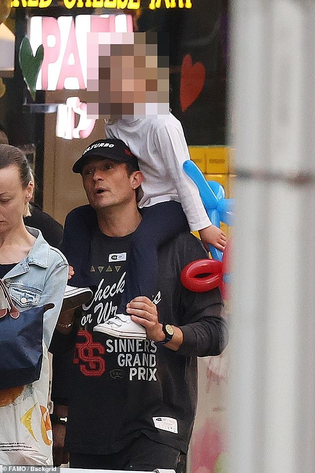 Ever the doting dad, Orlando carried Daisy on his shoulders ad they took at stroll around the city's CBD