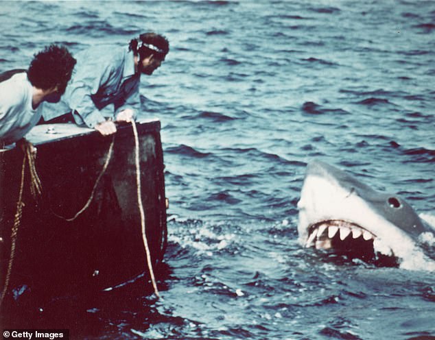 A scene from 1975 film Jaws, showing the mechanical creature in the water and actors Richard Dreyfuss and Robert Shaw as marine biologist Hooper and fisherman Quint