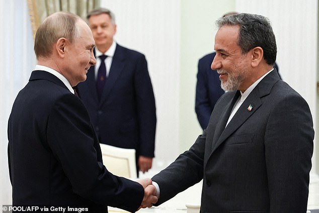 Vladimir Putin today vowed to back Iran and condemned 'groundless' aggression against its ally after the U.S. joined Israel in striking nuclear facilities on Sunday. Pictured: Putin and Iranian Foreign Minister Abbas Araghchi shake hands during a meeting at the Kremlin in Moscow on June 23, 2025
