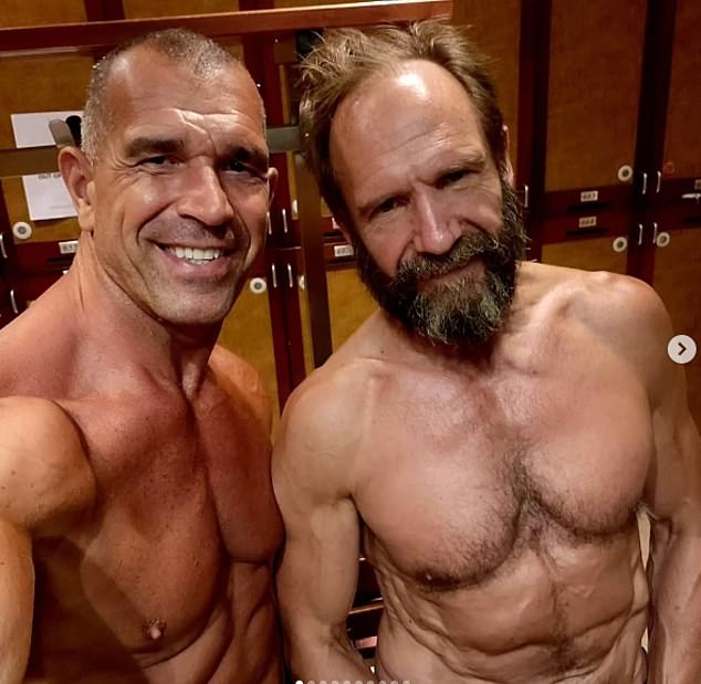 Fiennes's new physique is thanks to a strict workout plan set by his East London-based trainer Dan Avasilcai (left)