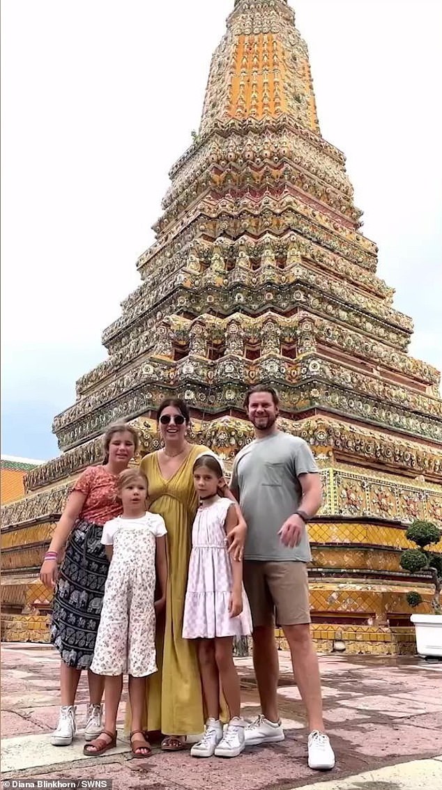 The family are pictured in front of a temple during their travels in Thailand