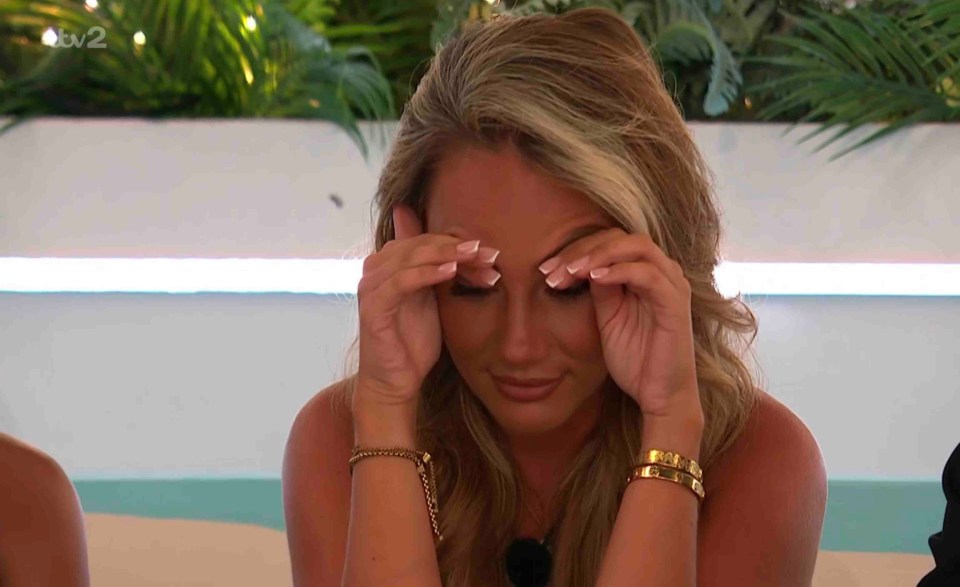 Helena from Love Island reacts to a text message.