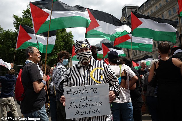A protester in a highly offensive mock concentration camp outfit