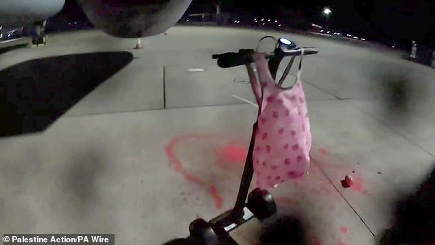 A clip shows one person riding an electric scooter up to an Airbus Voyager air-to-air refuelling tanker and appearing to spray paint into its jet engine