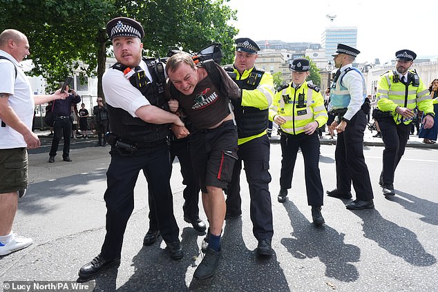One man at the protest is seen being removed from it by police responding to yesterday's rally