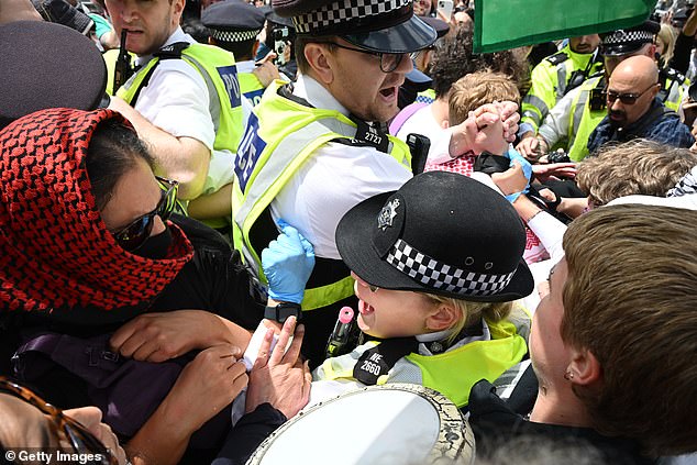 Police officers try to take control of a protest that spilled out of control in Trafalgar Square